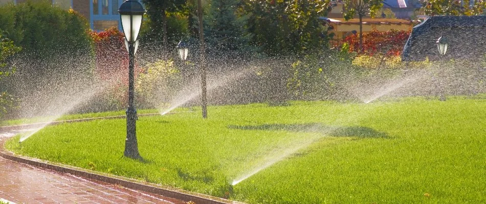 Irrigation sprinklers and lamp posts on a lawn in Upper Arlington, OH.